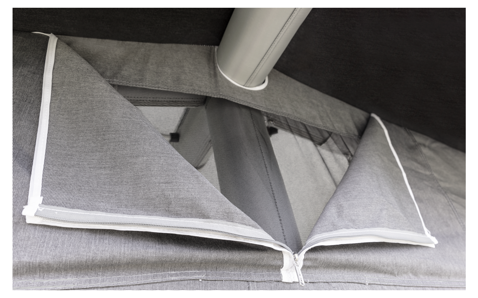 Folded gray pillows with white edges on a gray surface