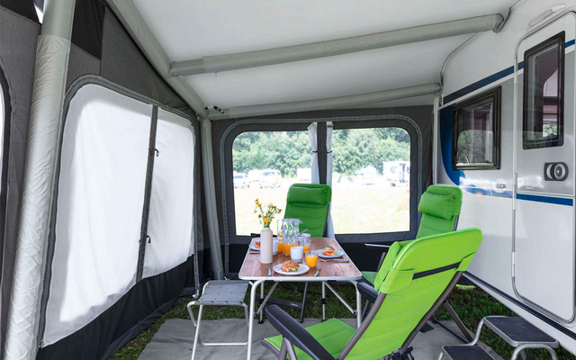 Interior of a tent with a table, two chairs, and several windows