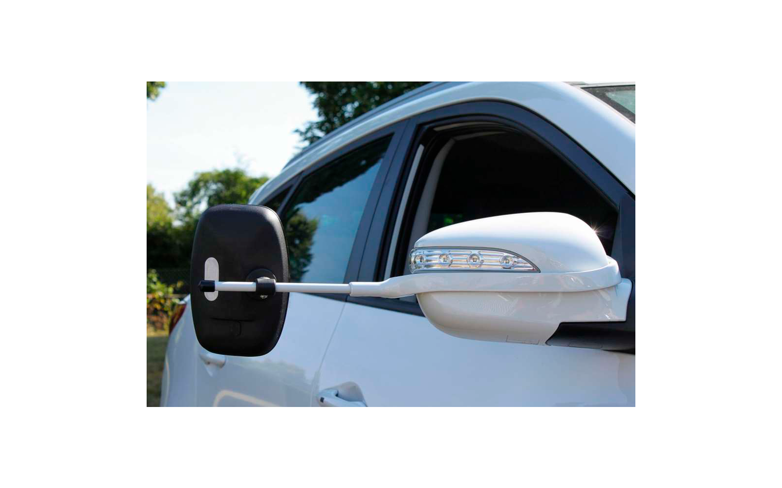 Eine Katze liegt auf einer weißen Fensterbank und blickt nach draußen