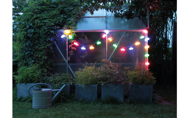 Abendliche Gartenparty mit bunten Lichterketten über einem Pavillon, umgeben von Pflanzen und Büschen