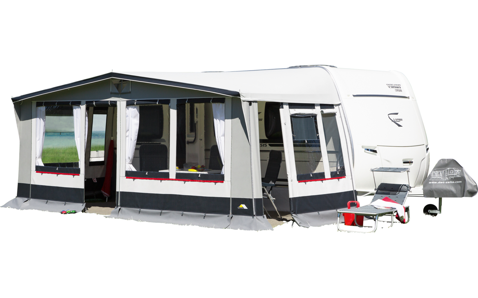 Caravan with attached awning on a green lawn under blue sky