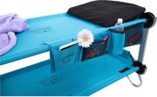 Blauer Campingstuhl mit Seitentasche, Wasserflasche und Blume