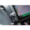 Close-up of a car radio with a rotary knob and a navigation screen
