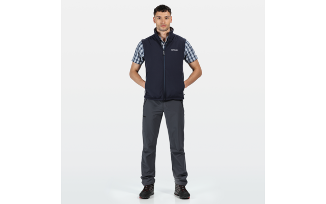 Mann in dunkler Arbeitskleidung steht frontal, Arme locker an den Seiten