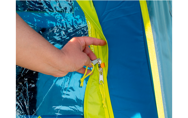 Hand öffnet einen Reißverschluss an einem blauen und gelben Kleidungsstück