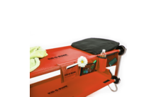 Red portable bench with flowers, water bottle, and bag, next to a green blanket