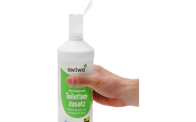 Hand hält weiße Flasche mit grünem Etikett und Schriftzug Toilettenzusatz