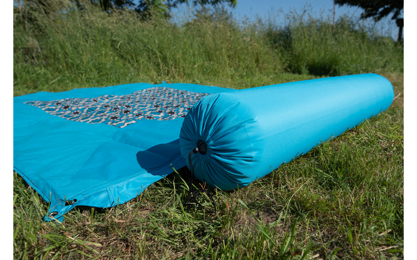 Blaues aufgerolltes Stoffstück mit Netz auf grünem Gras