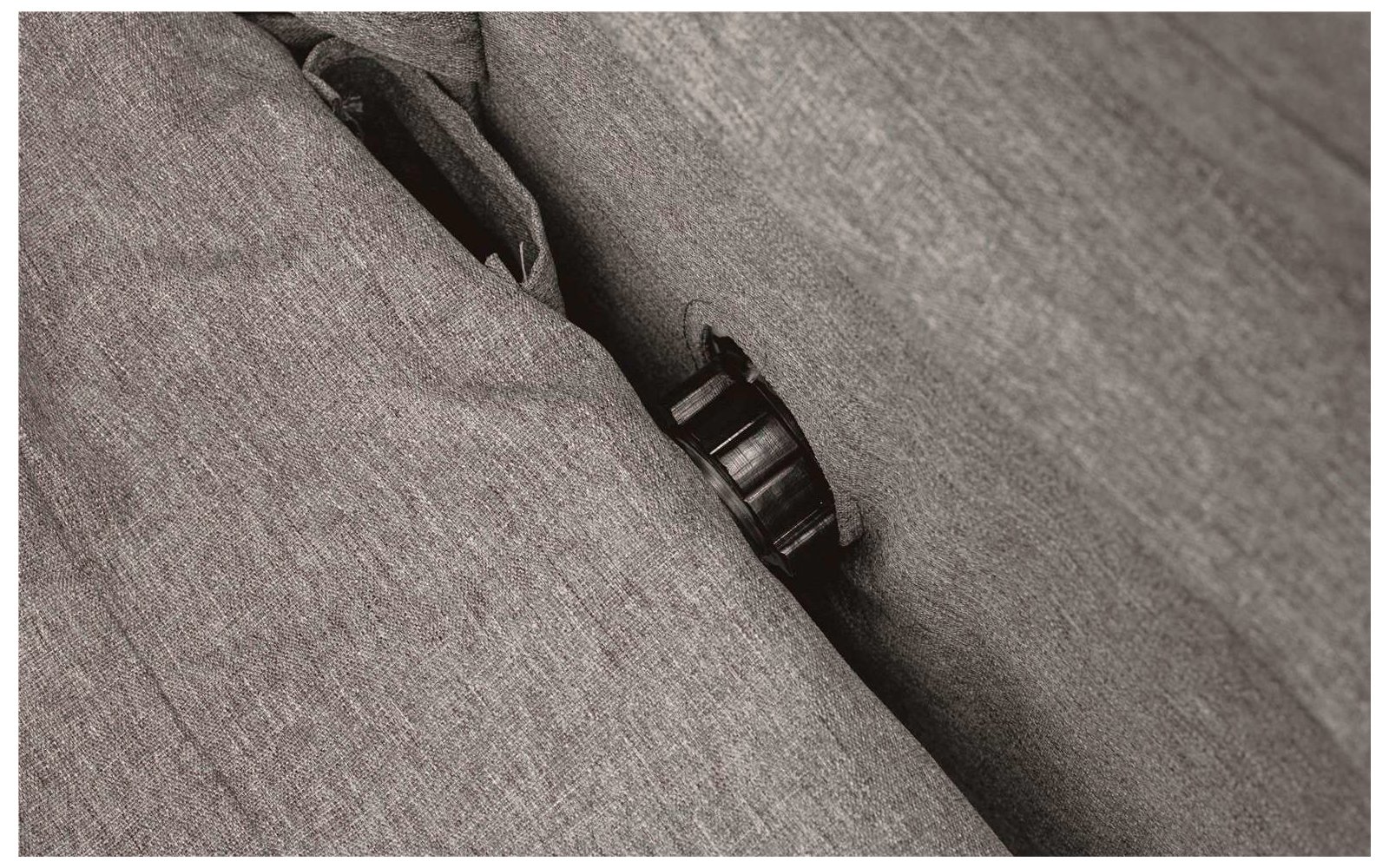 Close-up of gray fabric cover with a black buckle fastener