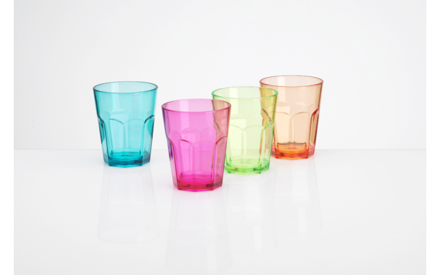 Vier bunte Trinkgläser in Blau, Pink, Grün und Orange auf weißem Hintergrund
