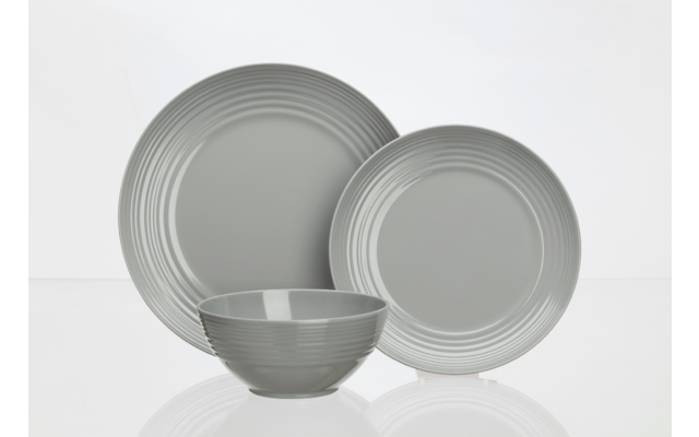 Drei graue Teller und eine graue Schale auf weißem Hintergrund