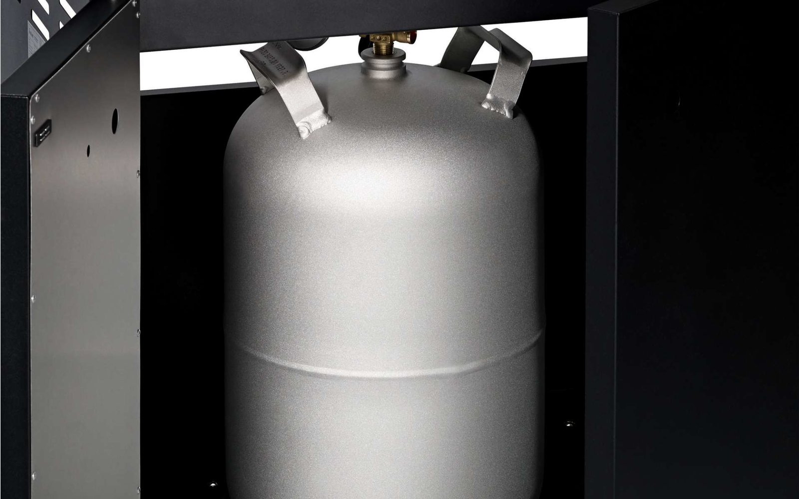 Silberfarbener Metallzylinder mit schwarzem Hintergrund und Deckenbeleuchtung