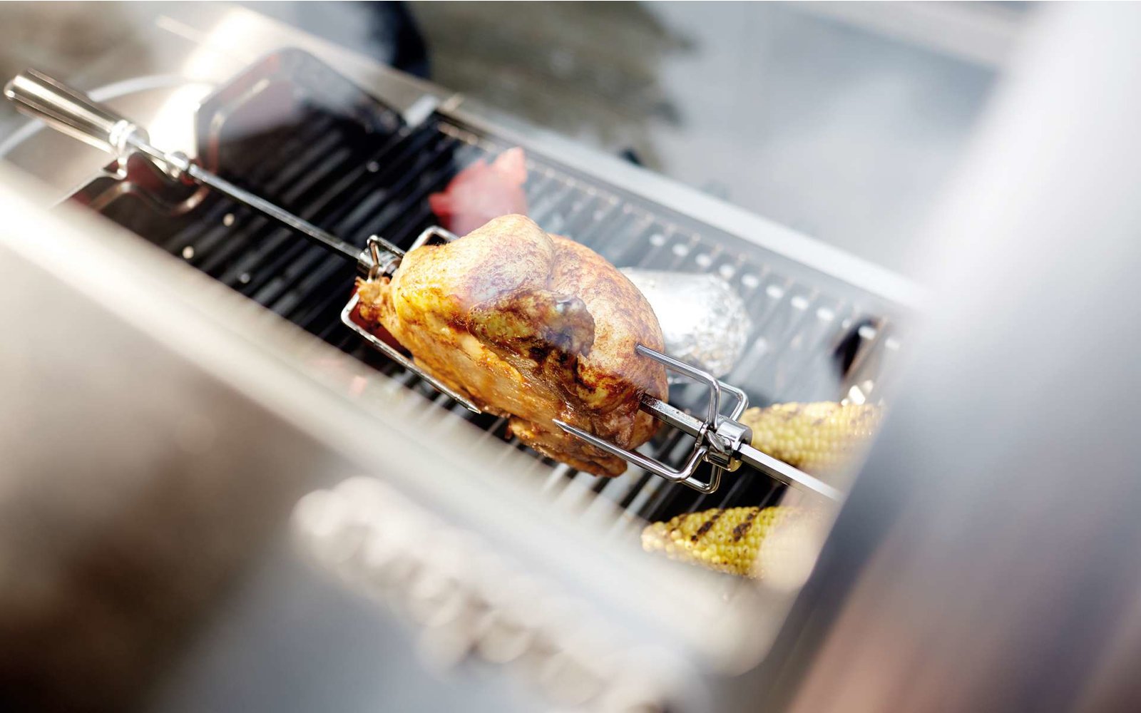 Eine weiße Kaffeetasse mit Milchschaum, daneben ein Glas Wasser auf einem Holztisch