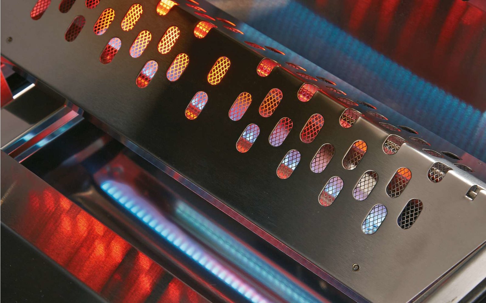 Nahaufnahme eines Metallgrills mit Löchern und rotem sowie blauem Licht im Hintergrund