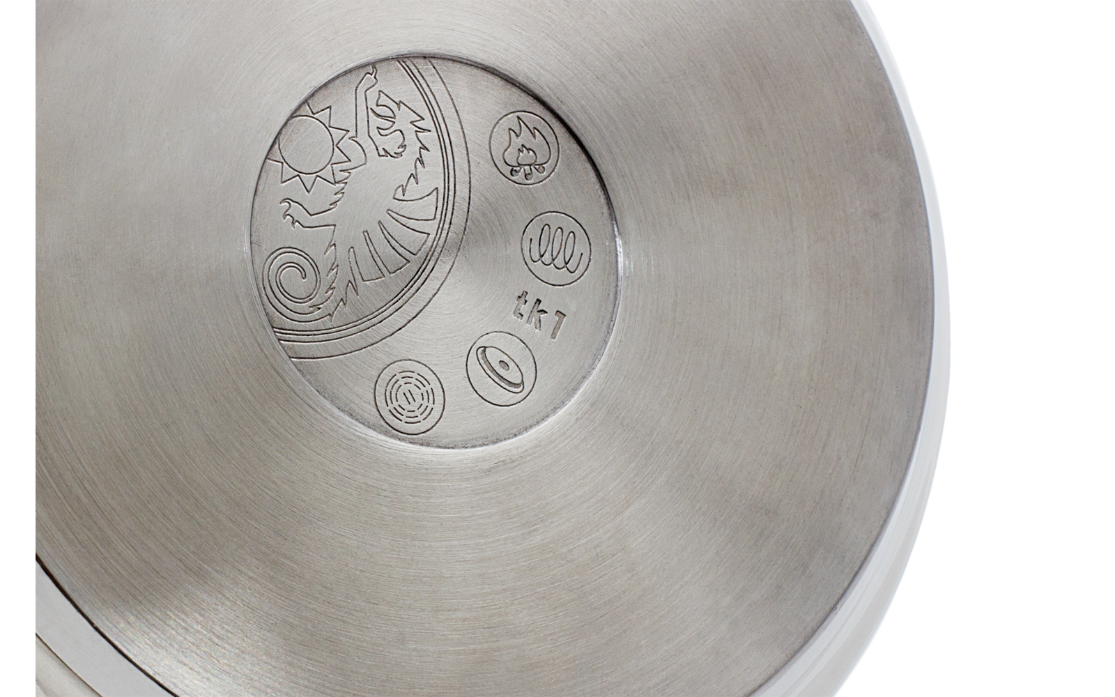 Nahaufnahme einer runden Metallfläche mit einem geprägten Muster aus Spiralen und Kreisen in der Mitte