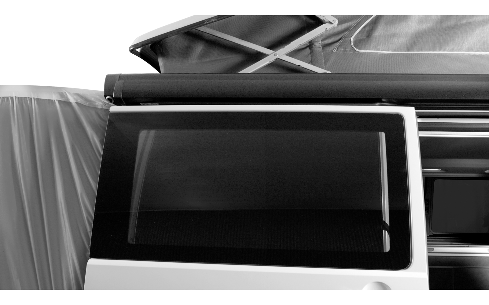 Geschlossenes Fenster eines weißen Fahrzeugs mit einem aufgeklappten Dachzelt