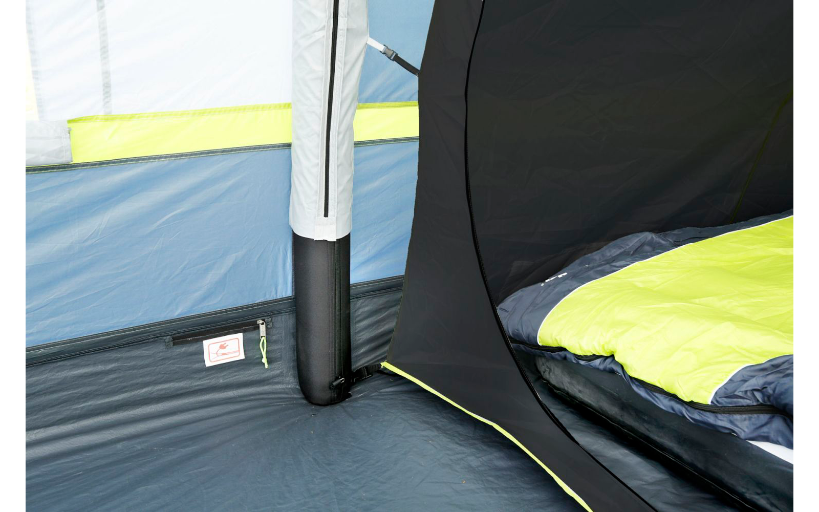 Blick in ein Zelt mit gelber, grauer und schwarzer Farbe und Campingausrüstung im Innenraum