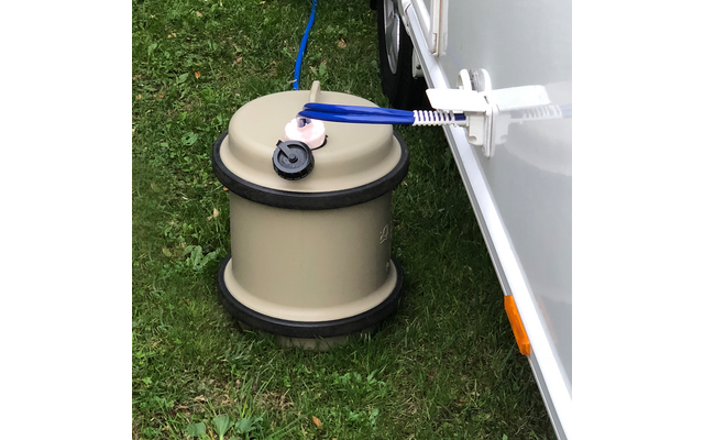 Erdanker mit Aufwickeleinrichtung auf Rasen neben einem weißen Fahrzeug