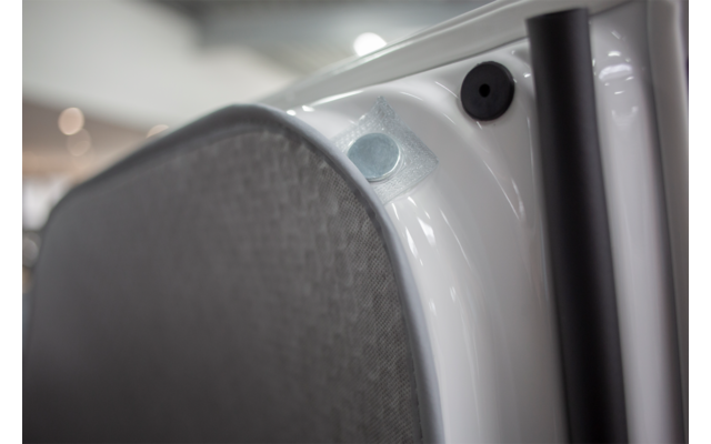 Close-up of a gray speaker cover on a white surface