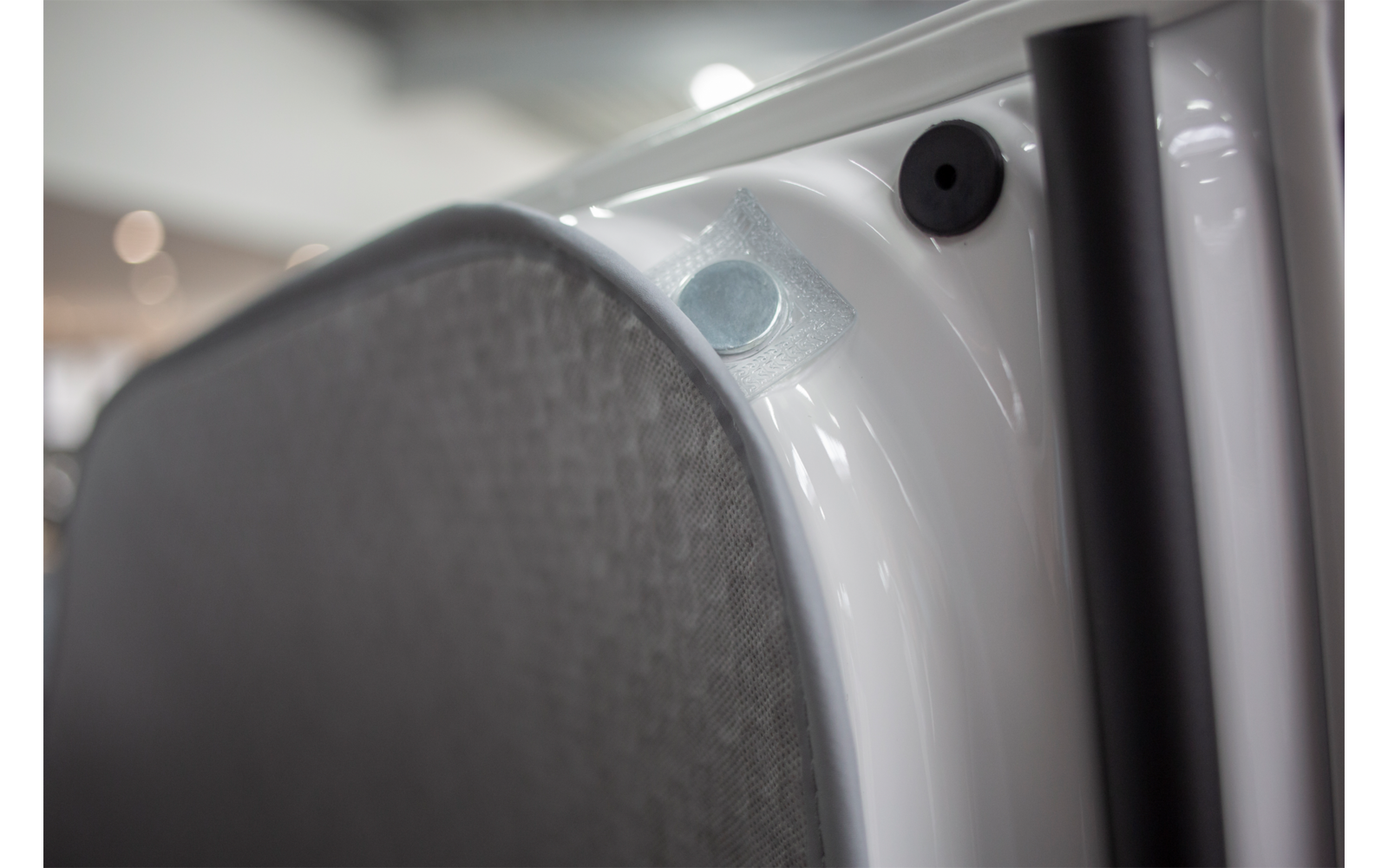 Close-up of a gray speaker cover on a white surface
