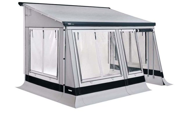 Auvent blanc et gris avec panneaux latéraux en plastique transparent fixé à une maison