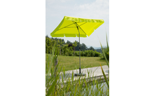 Parasol jaune à côté d'une piscine avec pelouse et arbres en arrière-plan