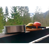 Blikken en fruit op een balkonleuning met bos en bergen op de achtergrond