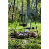 Parrilla sobre fuego abierto en un bosque con árboles verdes de fondo