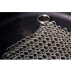 Nahaufnahme eines Kettenhemd-Abschnitts aus Metallringen auf einer schwarzen Oberfläche