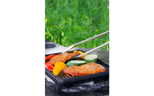 Filetes de salmón a la parrilla con verduras sobre una rejilla negra