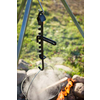 Ein schwarzer Angelrutenhalter mit Haken hängt über einem Lagerfeuer im Freien