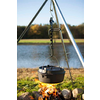 Ein schwarzer Kochtopf hängt an einem Metallgestell über einem Lagerfeuer am See
