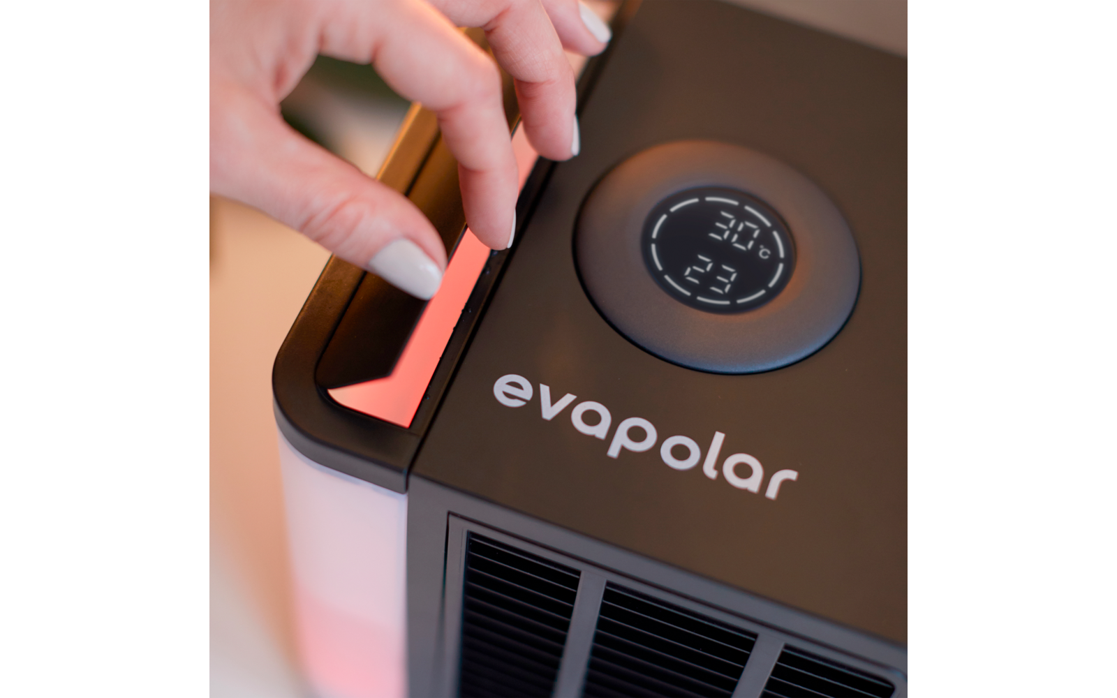 Hand stellt an einem elektronischen Gerät mit Display auf einem Tisch ein