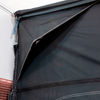 Closed black fabric awning attached to a white house wall