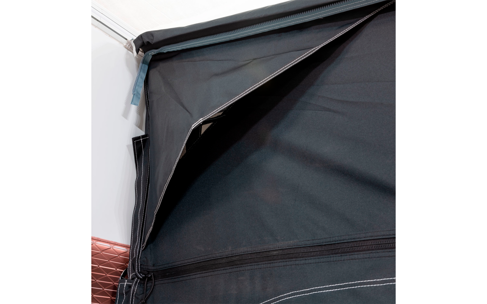 Closed black fabric awning attached to a white house wall