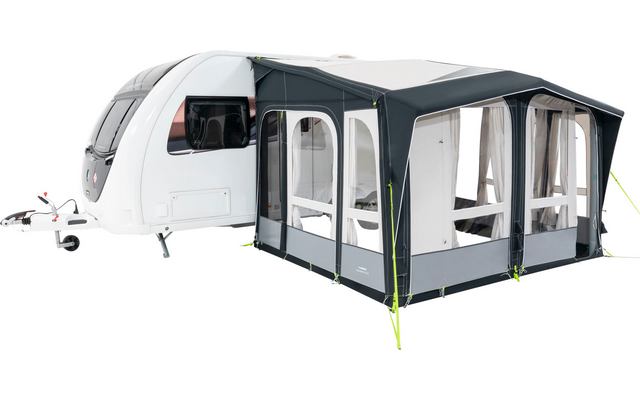A white caravan with an attached gray awning and windows