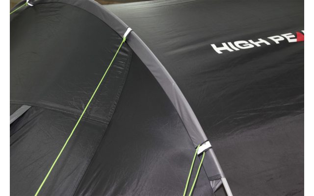 Close-up van een zwart tent met groene naden en witte letters