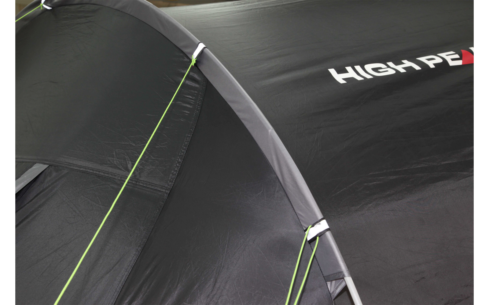 Close-up van een zwart tent met groene naden en witte letters