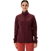 Femme portant un pull à col roulé marron et un pantalon rouge sur fond blanc