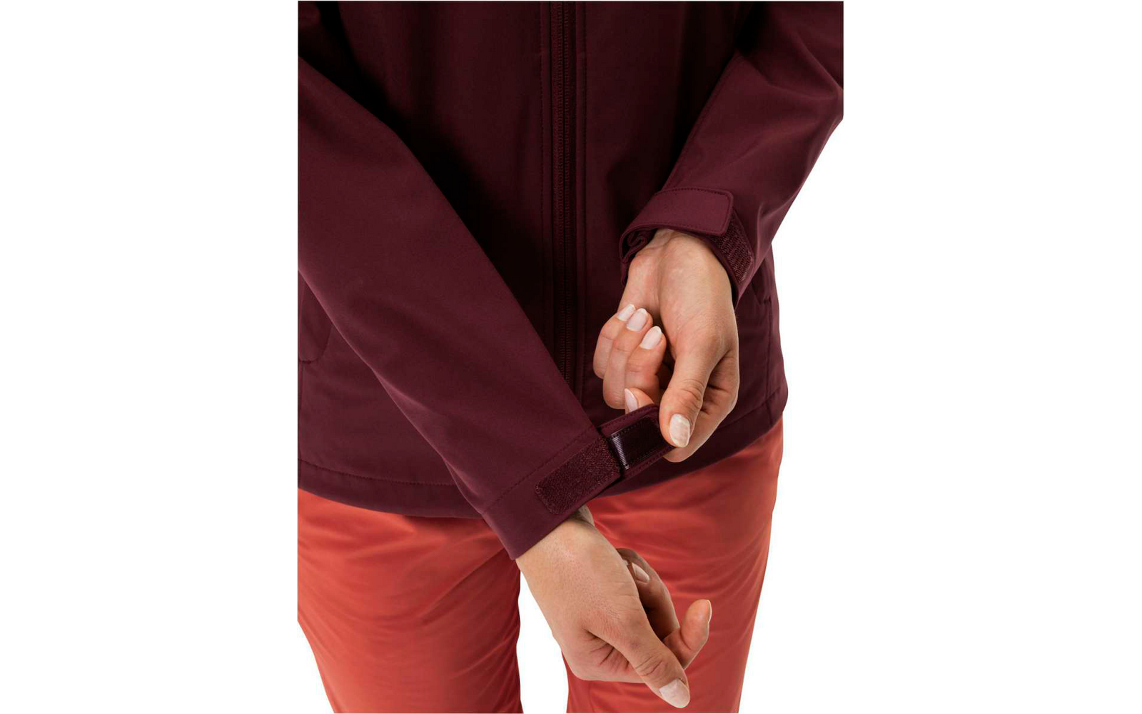 Main remontant la fermeture éclair d'un pantalon rouge