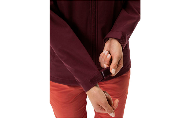 Main remontant la fermeture éclair d'un pantalon rouge