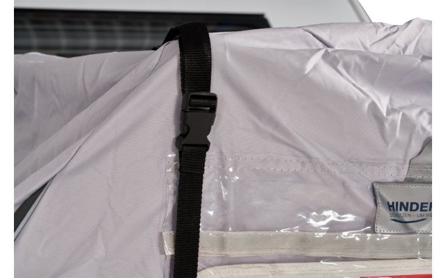 Weißer Wohnwagen mit aufgespanntem Schutzüberzug vorne