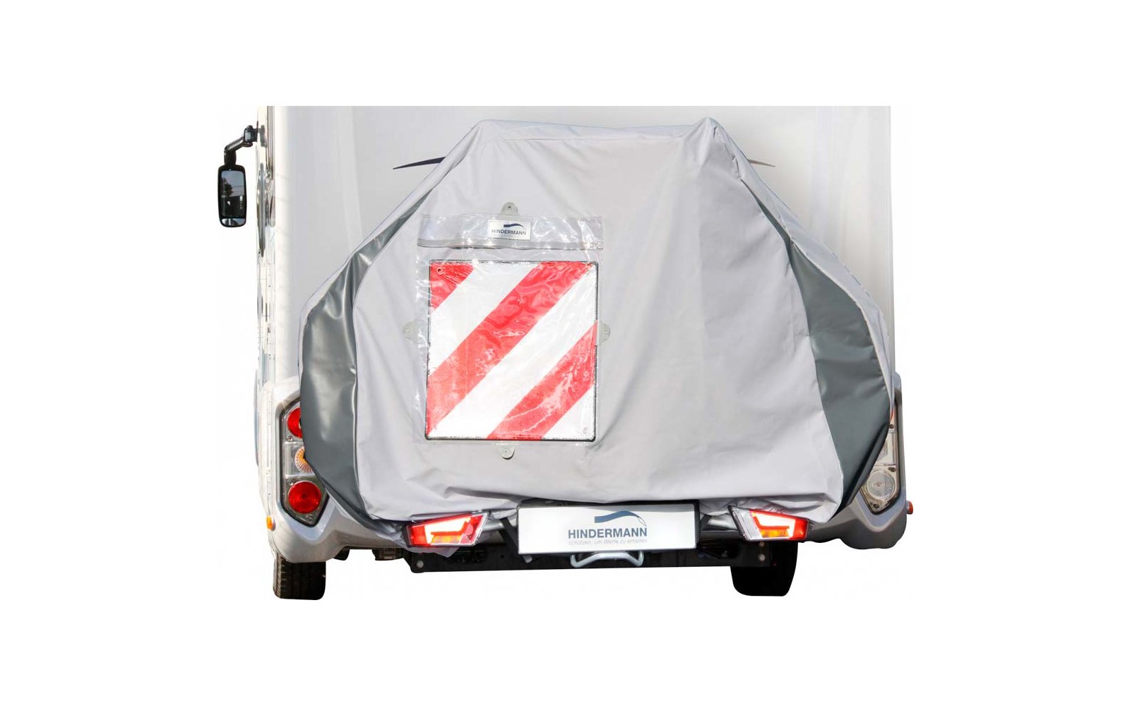Rückansicht eines Wohnmobils mit abgedecktem Fahrradträger und reflektierender Warntafel