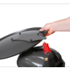Main ouvrant un seau noir avec un couvercle rouge