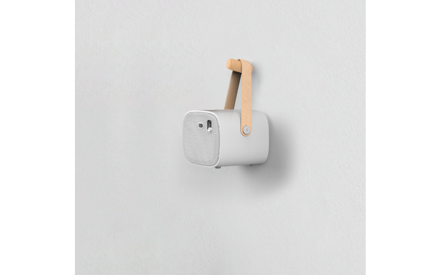 weiße tragbare Bluetooth-Box mit braunem Tragegriff, befestigt an weißer Wand