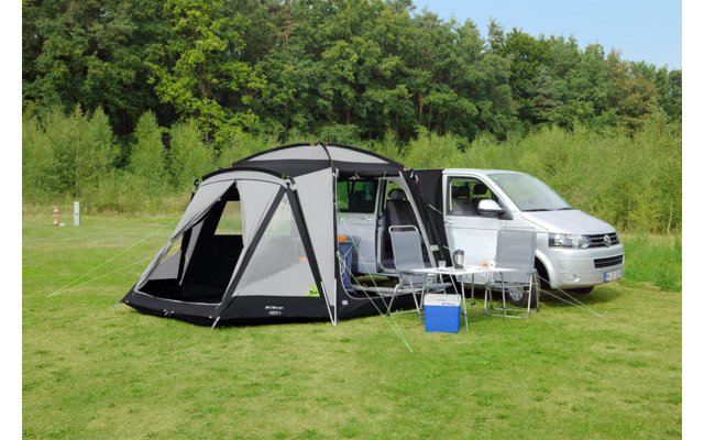 Auto met een opgezet grijs tent op een groen grasveld
