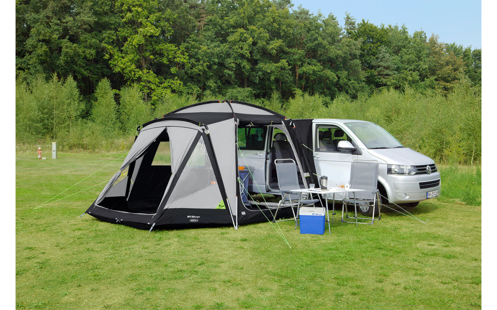 Auto met een opgezet grijs tent op een groen grasveld