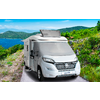 Camping-car sur une route de montagne étroite avec un lac et des collines vertes en arrière-plan