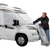 Uomo che stende una copertura grigia accanto a un camper bianco