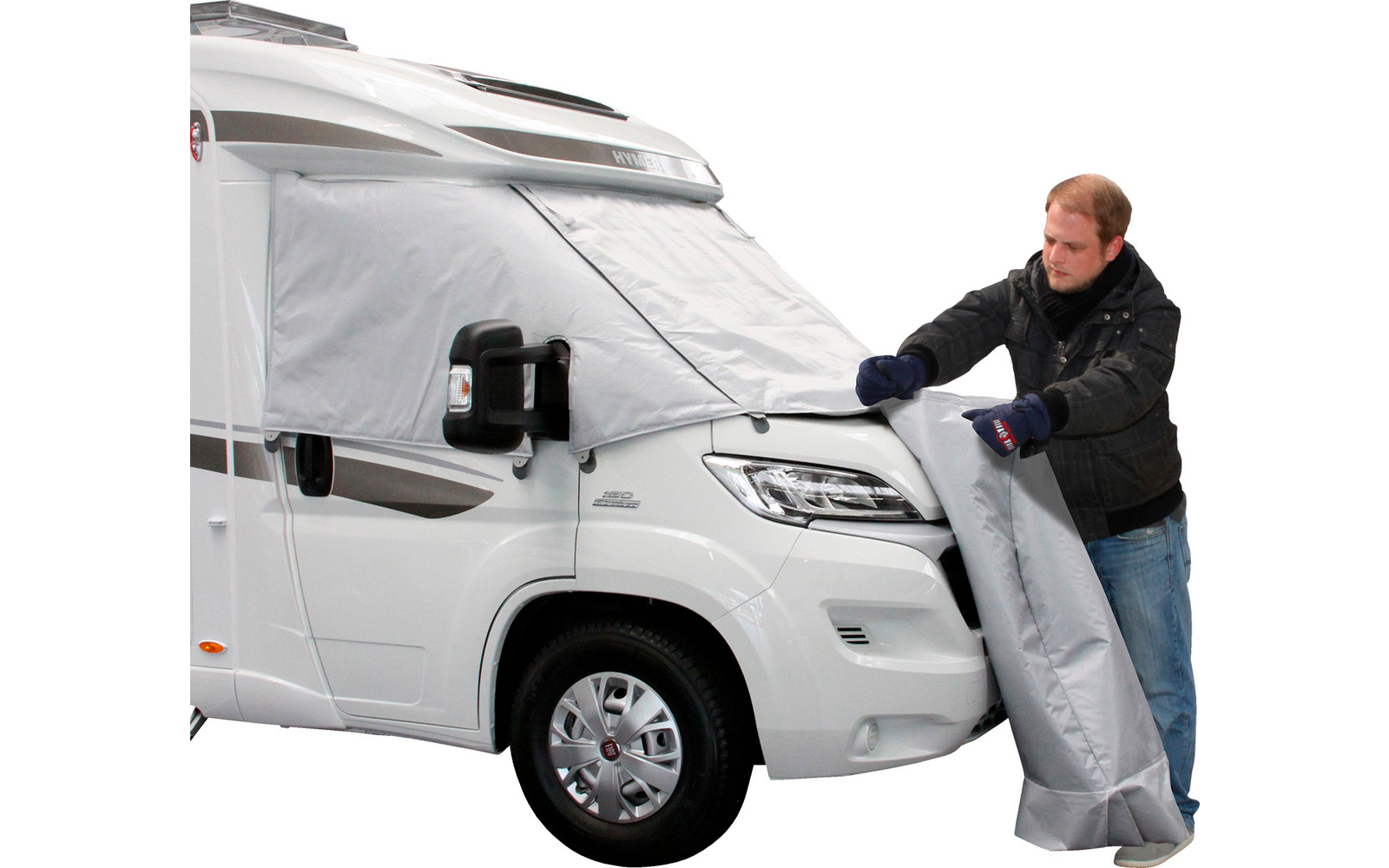 Uomo che stende una copertura grigia accanto a un camper bianco